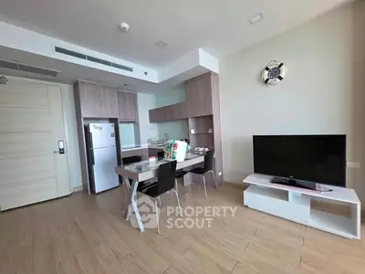 Modern open-layout kitchen and living area with sleek furniture and appliances.