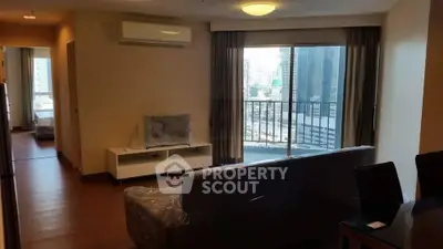 Spacious modern living room with balcony and city view in high-rise apartment.
