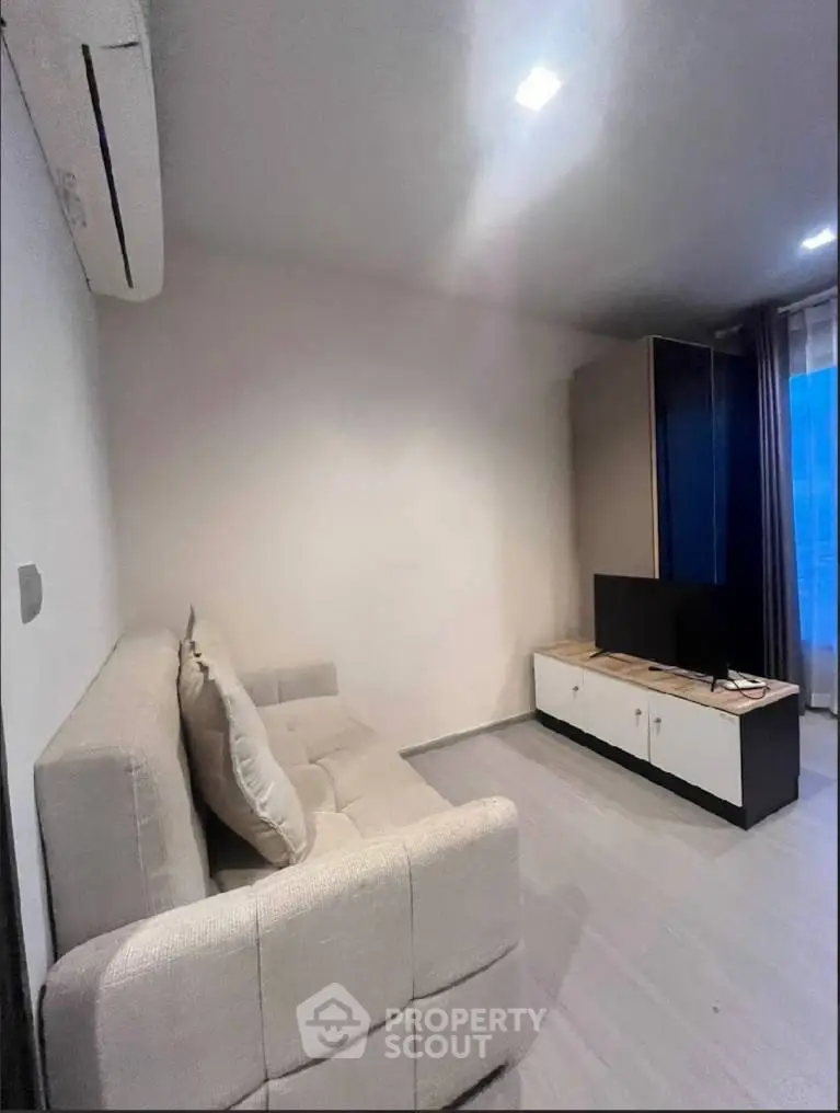 Modern living room with cozy sofa and sleek TV unit, perfect for relaxation.