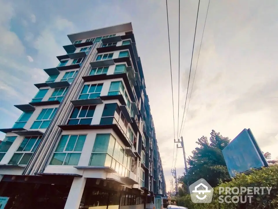 Modern multi-story apartment building with large windows and contemporary design.