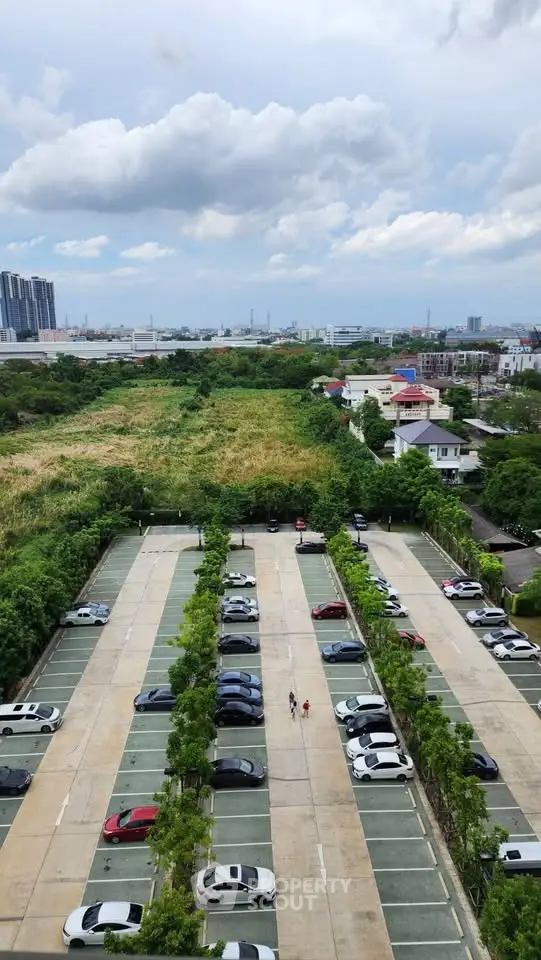 Scenic view of urban landscape with parking lot and lush greenery, ideal for real estate development.