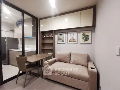 Modern living room with cozy sofa and stylish kitchen in open layout apartment.