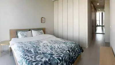 Spacious modern bedroom with stylish decor and ample natural light