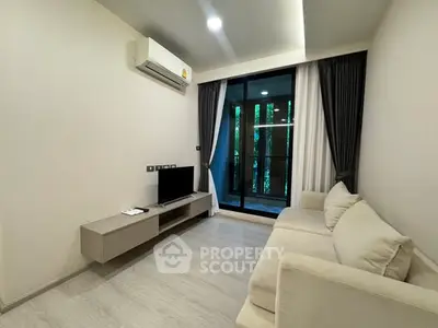 Modern living room with balcony view, featuring sleek furniture and air conditioning.