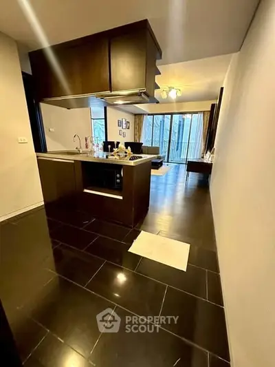 Modern open-layout kitchen with sleek dark flooring and stylish cabinetry