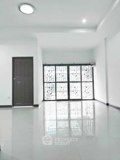 Spacious modern interior with glossy tiled floors and secure window grills.