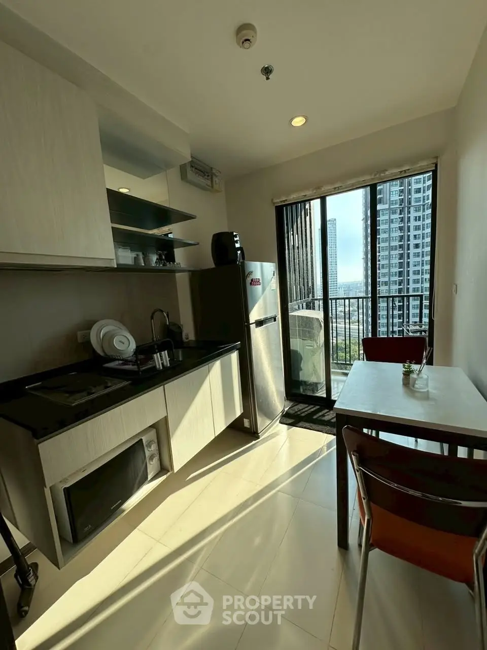 Modern kitchen with open layout and balcony view in high-rise apartment