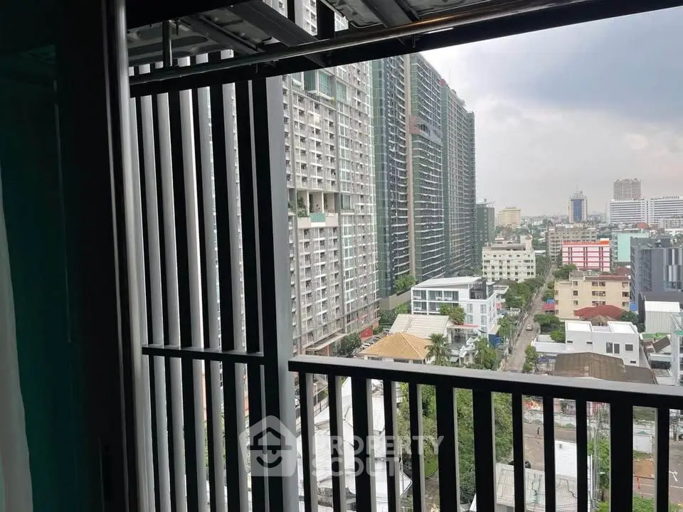 Stunning urban view from a high-rise balcony overlooking cityscape and modern architecture.