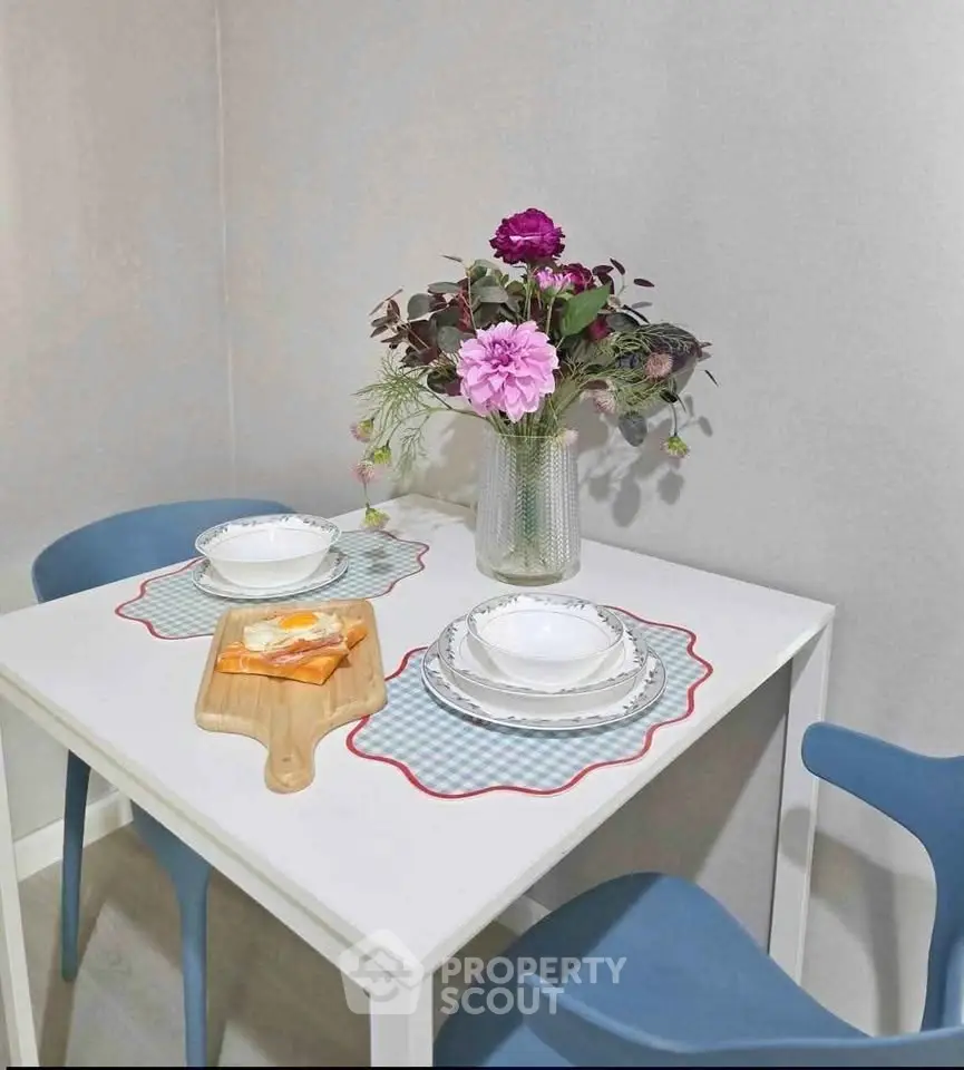 Charming dining nook with elegant table setting and vibrant floral centerpiece.