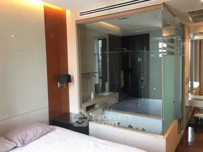 Luxurious bedroom with integrated glass-enclosed bathtub offering modern elegance and comfort.