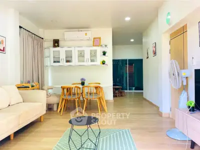 Spacious modern living room with dining area, featuring stylish furniture and bright lighting.