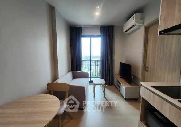 Modern living room with balcony view, featuring cozy seating and sleek furniture.