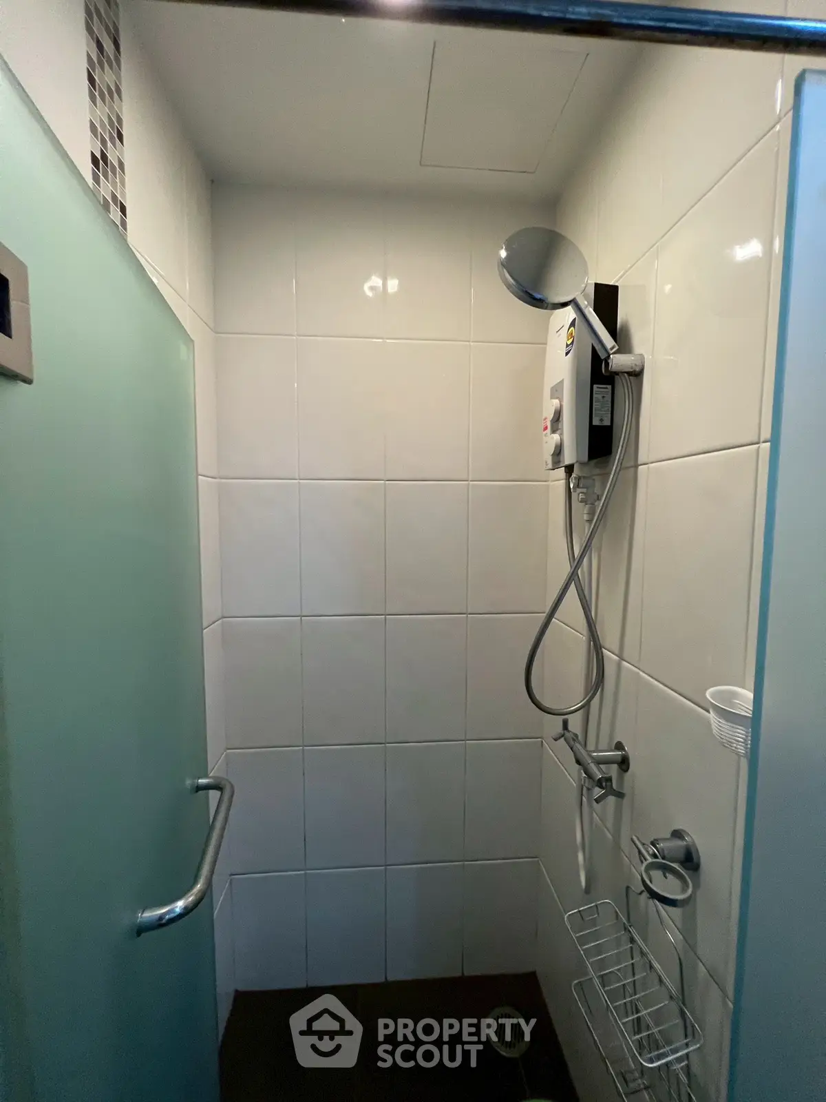 Compact bathroom with modern shower and frosted glass door