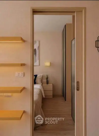 Modern bedroom with sliding door and stylish decor, featuring cozy lighting and wooden flooring.