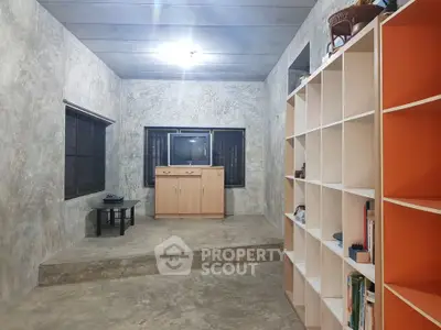 Minimalist living room with concrete walls and modern shelving unit