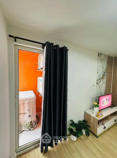 Modern living room with sliding door to balcony, featuring stylish decor and natural light.