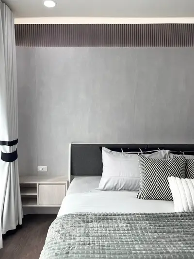 Modern bedroom with stylish decor and cozy bedding in a contemporary apartment.