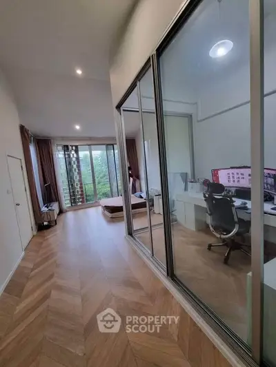 Spacious modern apartment with glass-walled study and balcony view