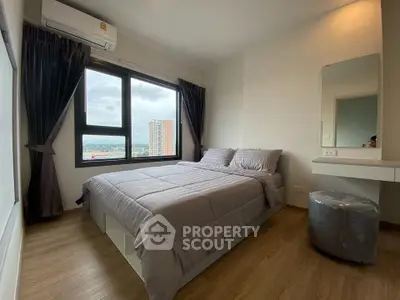 Modern bedroom with large window and city view, featuring elegant decor and natural light.
