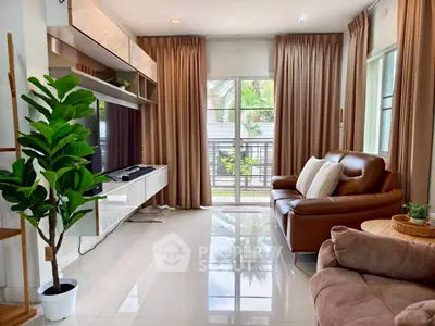 Stylish living room with modern furniture and large windows offering natural light and garden view.