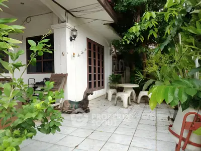 Charming garden patio with lush greenery and cozy seating area