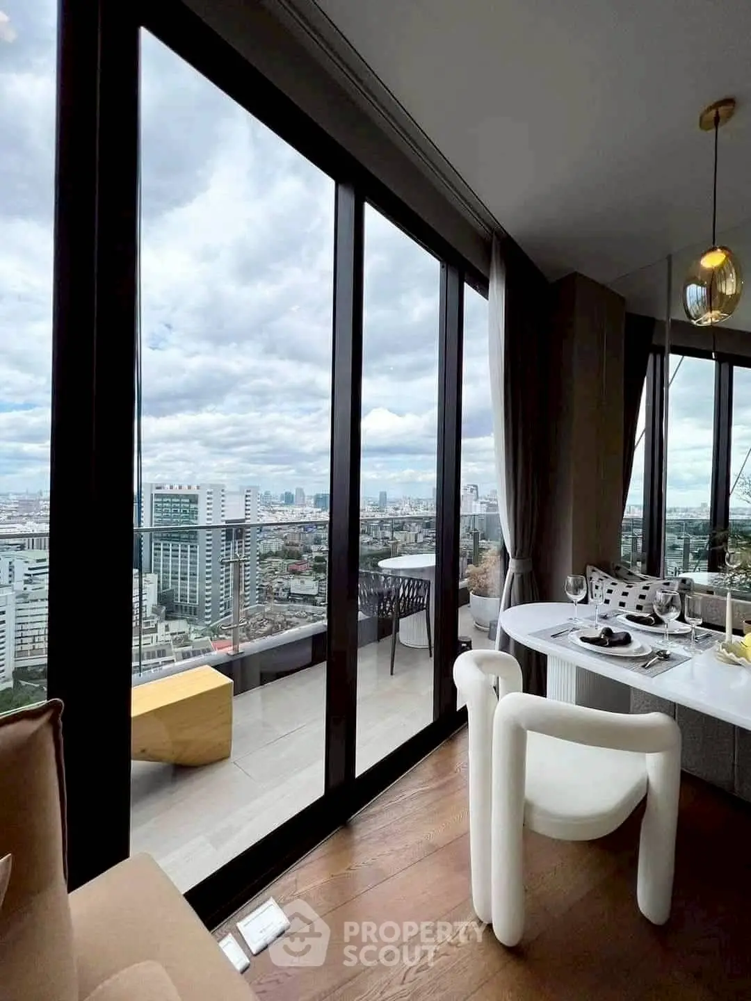 Luxurious high-rise apartment with stunning city view and elegant dining area.
