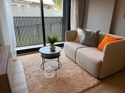 Cozy living room with modern sofa and large window offering natural light.