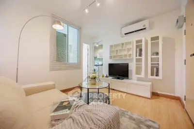 Modern living room with cozy sofa, stylish decor, and sleek TV unit in bright apartment.