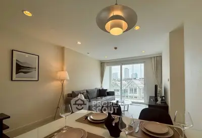 Modern living room with stylish decor and city view from large windows.