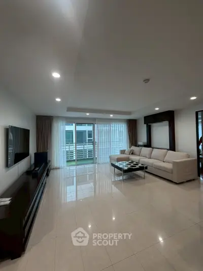 Spacious modern living room with large windows and elegant furnishings