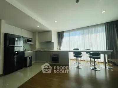 Modern kitchen with sleek design, featuring an open layout and stylish bar seating.