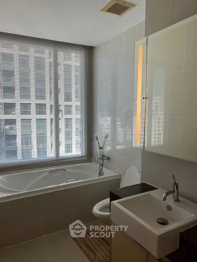 Modern bathroom with city view, featuring a sleek bathtub and stylish sink.
