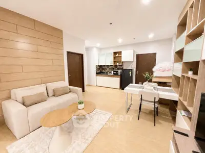Modern open-layout living room with stylish decor and kitchen area, perfect for contemporary living.