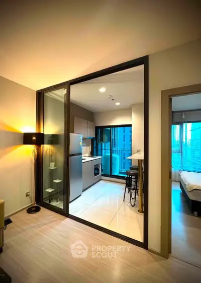 Modern apartment interior with open kitchen and cozy living area, featuring sleek design and city view.