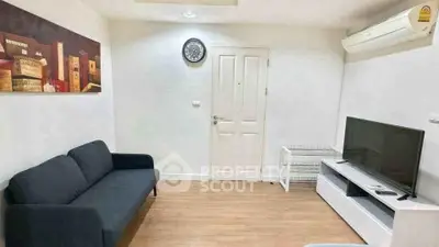 Cozy living room with modern decor, featuring a sleek sofa, wall art, and a flat-screen TV for ultimate relaxation.