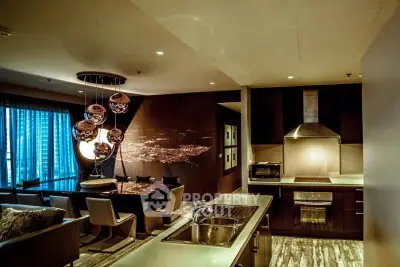 Luxurious modern kitchen with open layout and stylish dining area, featuring elegant lighting and sleek appliances.