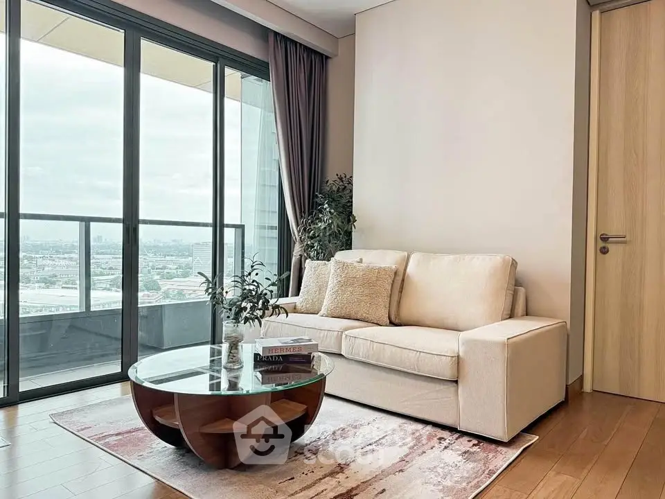 Modern living room with large windows and cozy seating area, offering a stunning city view.