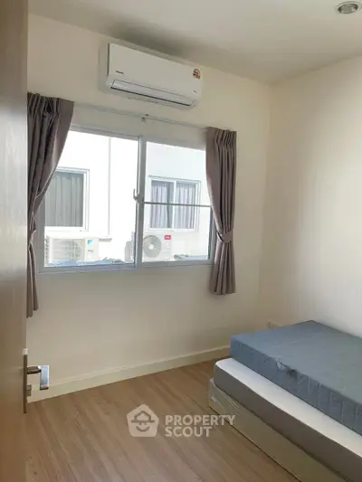 Cozy bedroom with air conditioning and natural light, perfect for relaxation.