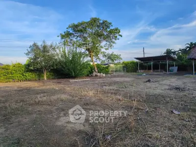 Spacious vacant land with lush greenery and clear blue sky, perfect for development opportunities.