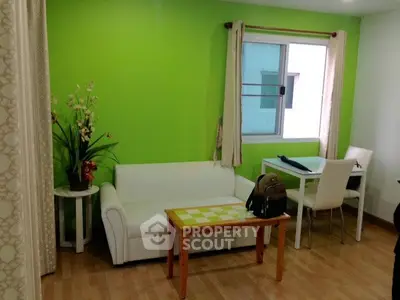 Charming living room with vibrant green accent wall and cozy white sofa