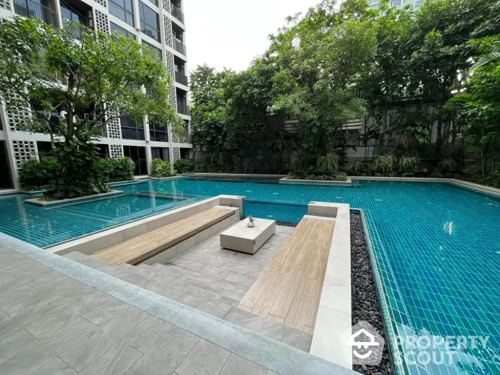 Luxurious apartment complex with serene pool and lush greenery