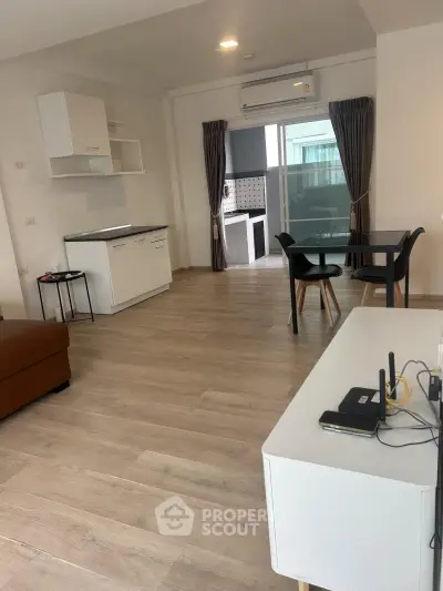 Spacious modern living room with open layout and stylish furniture, featuring a dining area and balcony access.