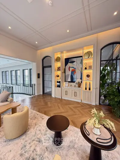 Luxurious living room with elegant decor and modern art, featuring stylish furniture and ambient lighting.