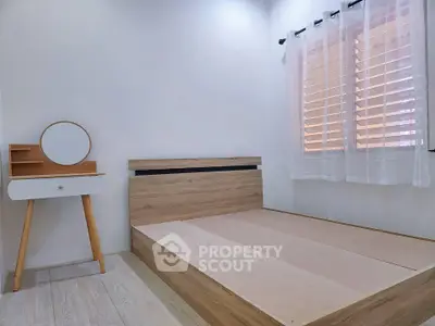 Minimalist bedroom with wooden bed frame and stylish vanity table