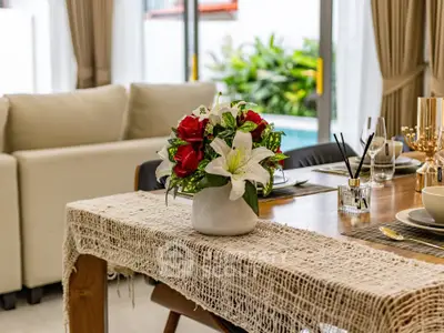 Elegant dining area with floral centerpiece and pool view, perfect for stylish entertaining.
