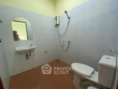 Spacious bathroom with modern fixtures and tiled walls, featuring a shower and toilet.