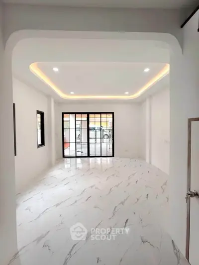 Spacious modern living room with marble flooring and large windows for natural light.