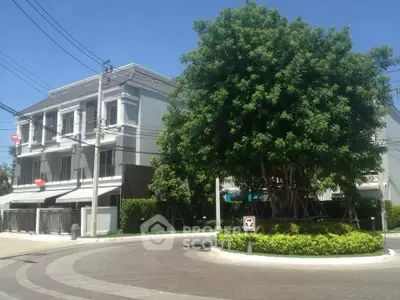 Modern townhouse with lush greenery and roundabout in serene neighborhood