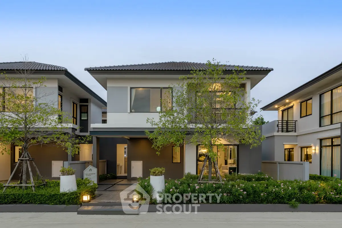 Modern two-story house with landscaped garden and contemporary design.
