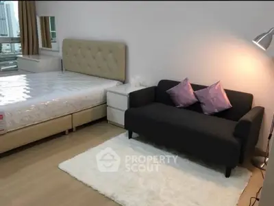 Modern bedroom with stylish decor, featuring a cozy bed and elegant sofa in a well-lit space.